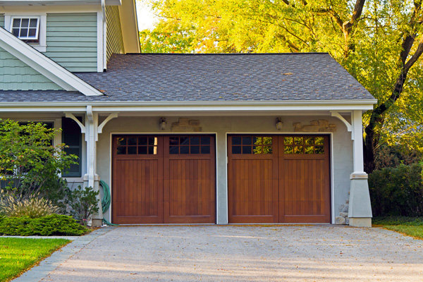 A photo of an elegant wood door garage attached to a home - Links to Home Insurance page