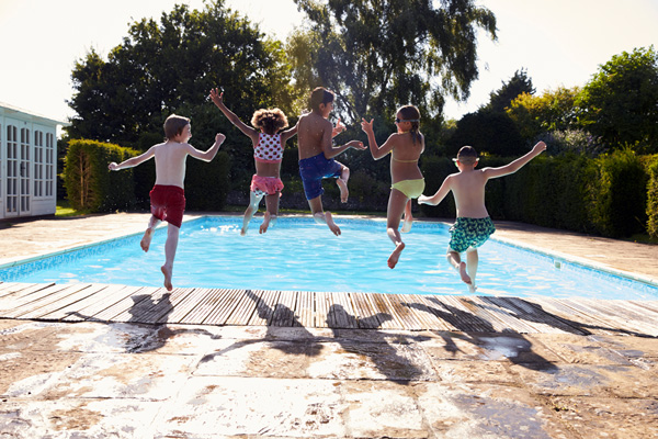 A photo of kids jumping into a pool - Links to Umbrella Insurance page