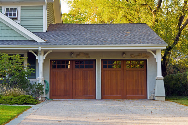A photo of an elegant wood door garage attached to a home - Links to Home Insurance page