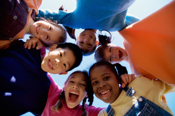 A photo of a group of children all smiling in a circle - Links to Human Services Insurance page