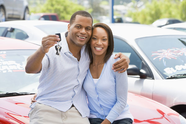Photo of a happy couple holding keys to their new car